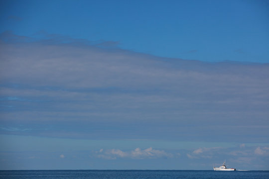 yacht sails on a calm sea against a beautiful blue sky