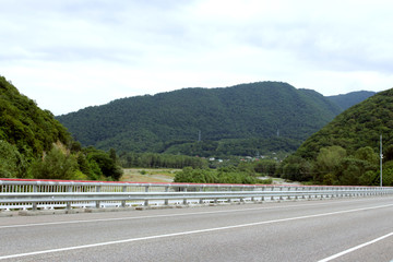 Driving on asphalt road and mountains on the horizon