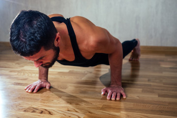 A muscular man does exercises to strengthen the muscles of the hands on the floor. push-up from the floor. concept of health promotion and beautiful body