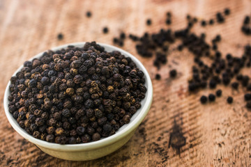 Close up of Black pepper in bowl on wooden background