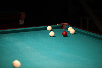 Playing billiard. Billiards balls and cue on green billiards table. Billiard sport concept. Pool billiard game. Russian pyramid (Russian billiard, pyramid billiards), cue sport.