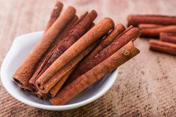 Close up of  cinnamon in bowl on wooden background
