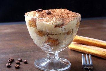 Piece of appetizing homemade tiramisu cake on plate in close up.