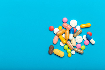 Pills are scattered over a blue background