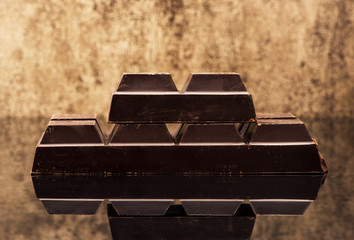 Blocks dark chocolate on a stone background
