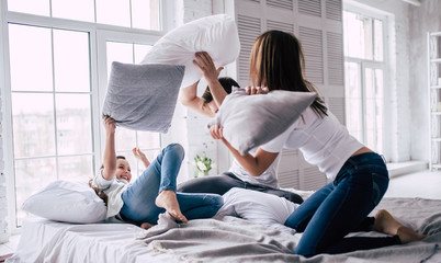 The happy family fighting with pillows