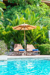 Beautiful umbrella and chair around swimming pool in hotel and resort - vacation concept