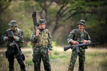 Squad of soldiers patrolling across the forest area.