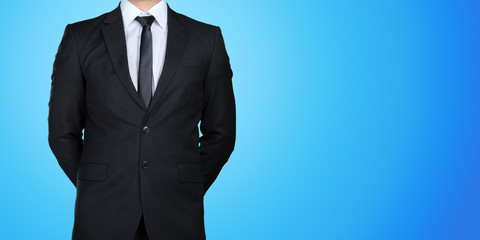 Obraz na płótnie Canvas Unrecognizable businessman in a formal black suit presenting, showing copy space for your design