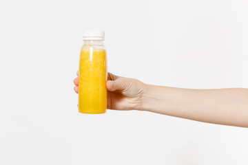 Close up female holding in hand yellow detox smoothies in bottle isolated on white background. Proper nutrition, vegetarian drink, healthy lifestyle, dieting concept. Advertising area for copy space.
