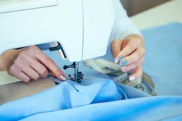 hands seamstress close-up. the tailor sews on the sewing machine. dressmaker and hands