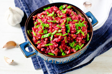 Buckwheat stewed with beetroot in a bowl on a wooden table