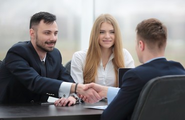 handshake financial partners sitting at the table