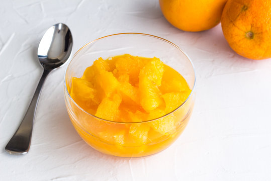 Bowl of peeled orange citrus fruit segments in juice