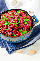 Buckwheat stewed with beetroot in a bowl on a wooden table