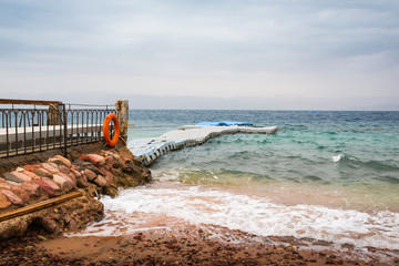 Naklejka premium Beach, sea and pier in the water on a cloudy summer day