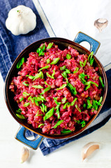 Buckwheat stewed with beetroot in a bowl on a wooden table