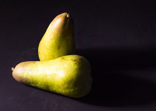 Two pears on black background
