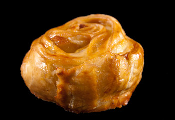 Bun with apple stuffing on a black background