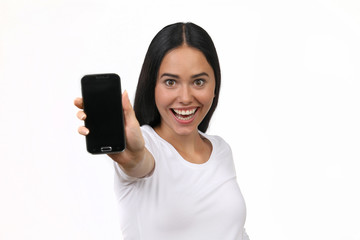 Hübsche junge Frau begeistert hält ein leeres Smartphone Display in die Kamera