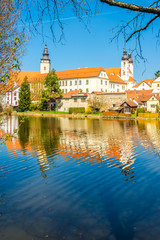 Fototapeta na wymiar View at the building of church in old city Telc with Ulicky pond - Czech republic, Moravia