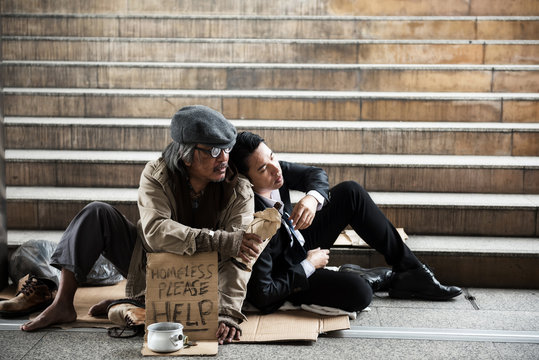 Homeless give beer to sad businessman