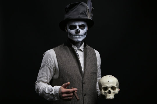 Guy in a makeup with a cigarette and a skull