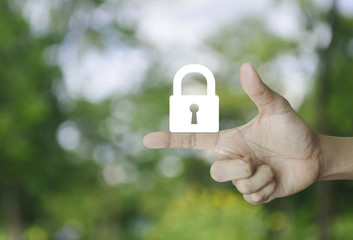 Key icon on finger over blur green tree background, Business security concept