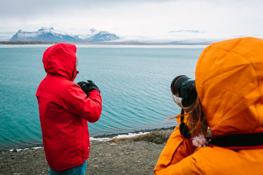 Tourists taking photographs of river in the Jokulsarlon glacier lagoon in Iceland - Stock Image