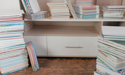 Fototapeta premium Pile of books on the floor and on the closet.