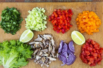 Set of chopped fresh vegetables with lime and beef on wooden board. Taco ingredients. Top view. From above. Flat lay.