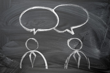 speaking of people. two man in ties silhouette and speak bubbles chalk hand drawn on the blackboard.