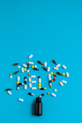 Spilled pills on a blue background. Help sign