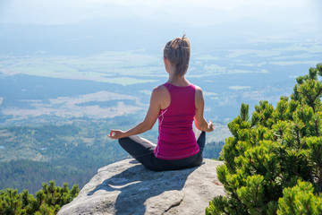 Naklejka na ściany i meble young woman meditate on top of the mountain