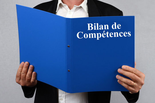 Homme consultant le dossier bilan de comp&eacute;tences 