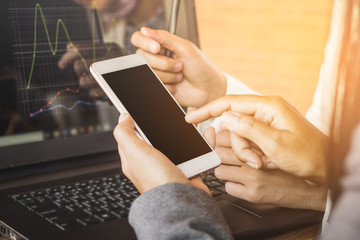 two businesswoman woman working together using smart phone and laptop with financial graph 