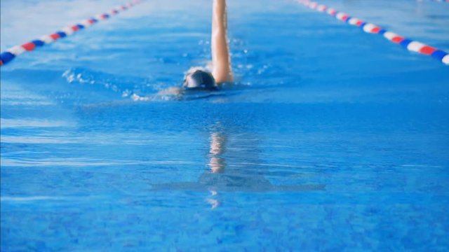 A person swims in a pool, close up.