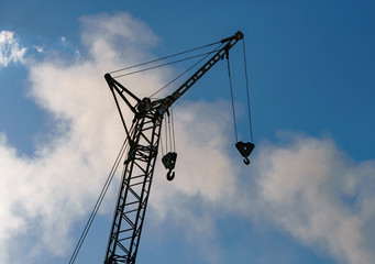 Silhouette construction crane on sunset sky