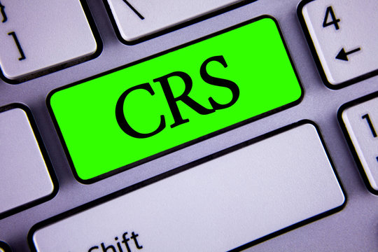 Handwriting text Crs. Concept meaning Common reporting standard for sharing tax financial information written on Green Key Button on White Keyboard with copy space. Top view.