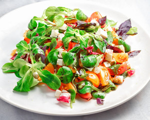 Fresh vegetable salad. Red and yellow tomatoes, Basil, goat cheese. Concept: healthy food.