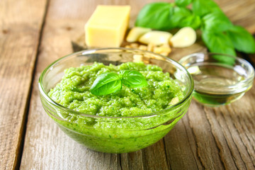Homemade pesto sauce. Ingredients. Cheese, garlic, basil, pine nuts, olive oil on an old wooden table.