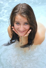 Sexy female beauty relaxing in hot tub outside.