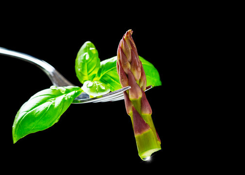 Green asparagus - asparagus tip and basil on fork