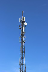 Radio tower with antennas on a blue sky background. Metal construction. Wireless tezhnologii. Transmission of a tele-radio signal. Egology of the external environment. copyspace.