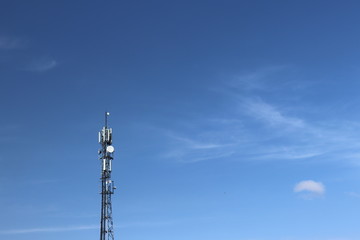 Obraz premium Radio tower with antennas on a blue sky background. Metal construction. Wireless tezhnologii. Transmission of a tele-radio signal. Egology of the external environment. copyspace.
