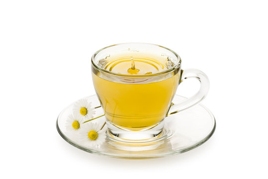chamomile in glass cup with splashing drop and daisy on white background