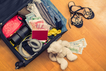 suitcase with things teddy bear and a foreign passport. Asian money and hundred-dollar bills for travel. Concept