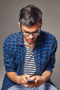 portrait of modern young man with mobile phone in a studio