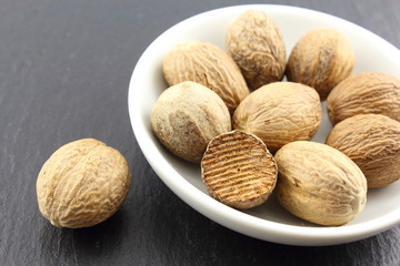 nutmeg seeds in a small white bowl