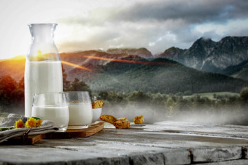 Fresh milk and landscape of mountains with fog and sunrise. Free space for your milk product. 